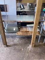 Front-angle view of stainless steel utility table with lower shelf and miscellaneous contents (not included)