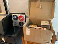 Photo showing a side view of the box filled with CDs beside an empty black CD case.