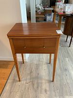 Full view of wood sewing table with closed front panel