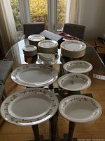 Overview of stacked plates, bowls, platters, and gravy boat on table