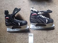 Pair of men's black hockey skates with white laces and white blade holders shown side profile.