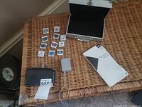 Nintendo 3DS games, charger, operation manual, and carrying case laid out on wicker surface.