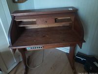 View of the open roll top desk showing the desktop, inner small drawers, and compartments.