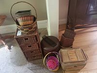 Overview of all baskets and storage items arranged on floor showing various sizes and styles including 4-drawer wicker storage unit and smaller baskets.