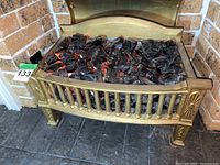 Front view of metal fireplace insert with faux coal showing detailed design and glowing embers effect.