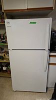 Front view of white Frigidaire top freezer refrigerator with closed doors.