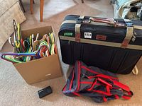 Box of assorted plastic hangers, Watchdog travelling alarm, lightweight sports bag and Ascot luggage suitcase.