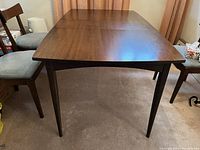 Table viewed from front with leaf inserted and two chairs at sides
