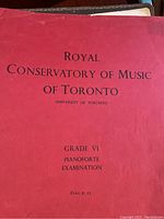 Red cover book labeled Royal Conservatory of Music of Toronto Grade VI Pianoforte Examination