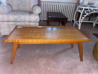 Full view of the rectangular pine coffee table placed on carpet, showing tabletop and legs.