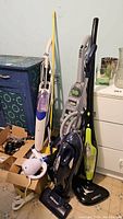 Lot overview showing five cleaning and home appliances including three steam mops/vacuums, an electric broom and a boxed handheld appliance.