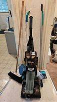 Front view of Fantom Fury upright vacuum with various cleaning tools behind it