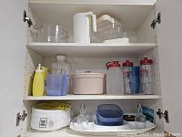 Photo of shelves inside cabinet showing various plastic serveware, water bottles and other containers