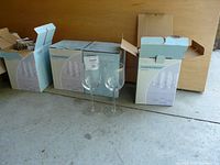 Seven boxes of wine glasses, with two wine glasses placed outside for display.