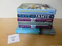 Stack of six Jamie Oliver cookbooks viewed from the side showing titles and spines