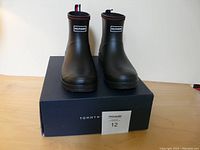 Front view of the new black ladies rubber boots on box showing brand and style.