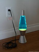 Lava lamp plugged in and turned on showing blue liquid and yellow wax inside.