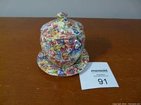 Floral print mustard pot with lid on matching plate.