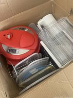 Top view of Instant Pot and assorted plastic containers tightly packed in a cardboard box