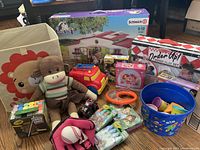 Setup photo showing most of the assorted kids toys including plush monkey, fire truck, bucket with toy dishes, and craft kits