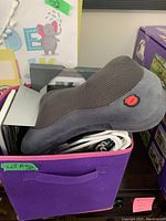 Gray mesh ergonomic massager placed in a purple fabric storage bin