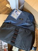Photo of navy blue Munchkin diaper bag with front pocket and tag