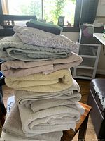 Stack of assorted towels in neutral colors on a chair