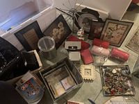 Photo of a variety of household and decorative items including framed artwork, linens, storage boxes, costume jewelry, and figurines.
