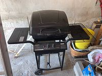 Full view of the black Master Chef propane barbecue grill with lid closed and extra grill attachment on the right side, mounted on a metal stand with wheels.