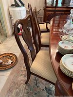 Side view of four wooden chairs with fabric upholstery in dining room.