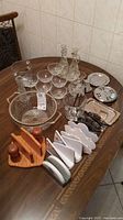 Overview of glasses, oil and vinegar bottles on tray, wooden napkin holders, salt and pepper, ceramic plates and small trays on table
