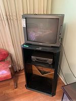 Overall view of the black entertainment cabinet with Legend CRT TV on top and Sanyo VHS player inside