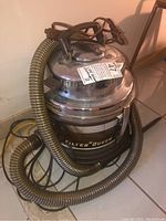 View of the Filter Queen vacuum cleaner showing the hose wrapped around the top and the power cord.