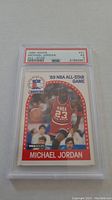 Photo of 1989 Hoops Michael Jordan #25 basketball card graded PSA 5 EX, showing card front with Jordan in NBA red All-Star jersey with number 23.