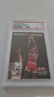 Front view of 1992 Skybox Michael Jordan basketball card in PSA graded case showing image of Michael Jordan shooting a basketball while guarded, PSA grade 6 EX-MT.