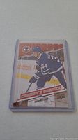 Auston Matthews rookie hockey card in clear protective case showing front of card with player skating in Toronto Maple Leafs jersey number 34.