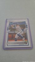 Single Bo Bichette rookie baseball card in a clear protective holder laid on white surface.