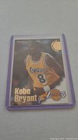 Front view of Kobe Bryant rookie basketball card in protective sleeve showing the player in Lakers jersey number 8.