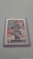 Front photo of Shohei Ohtani baseball card in protective sleeve on gray background