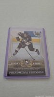 Sidney Crosby rookie hockey card in protective sleeve, front view showing player in Penguins uniform.