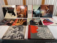 Twelve jazz jazz LP records displayed on a table showing front covers with various artists and styles.