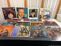 Photo showing 22 Frank Sinatra vinyl LP records arranged on a surface, featuring visible album covers with Frank Sinatra portraits and titles.