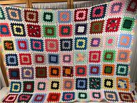Full view of colorful crocheted blanket showing whole pattern and size