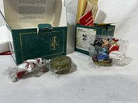 Photo of both Disney Classic Collection ornaments including Mickey Mouse and 101 Dalmatians figures alongside their original boxes with wear and staining.