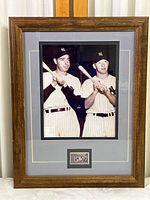Framed black and white photo showing Joe DiMaggio and Mickey Mantle holding bats in their New York Yankees home uniforms, double matted and surrounded by wooden frame.
