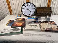 Overview photo of the office collection on white table showing clock, calligraphy kits, pens, notecards, ruler, tape dispenser, index cards, and envelopes.
