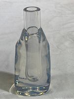 Front view of a clear thick-walled Sugahara craft glass bud vase showing cylindrical neck and polished thick glass body.