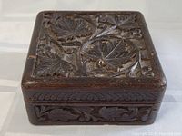 Clear view of the carved wooden cigarette box's top and side to show detailed hand-carved patterns and condition.
