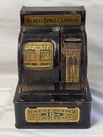 Overall front view of the Uncle Sam steel coin register bank showing details of coin slots, amount dial, and Uncle Sam illustration