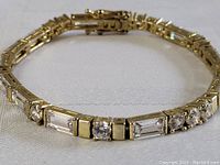 Close-up image of the gold plated bracelet showing the clear rectangular baguette crystals and round crystals set in the band.